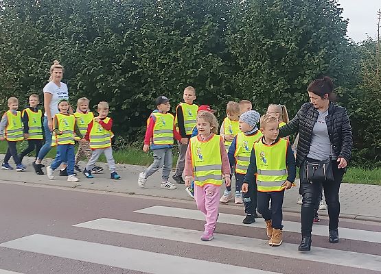 nauczycielka przeprowadza dzieci przez jezdnię