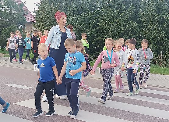 nauczycielka przeprowadza dzieci przez jezdnię