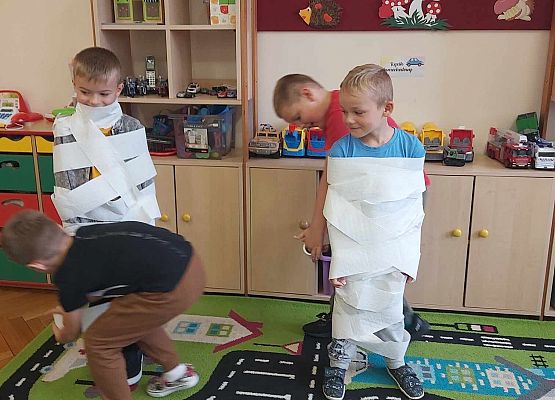 chłopcy bawią się w mumie