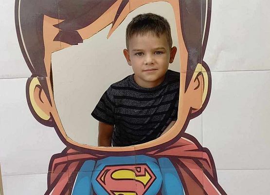 chłopiec pozuje do zdjęcia w fotobudce