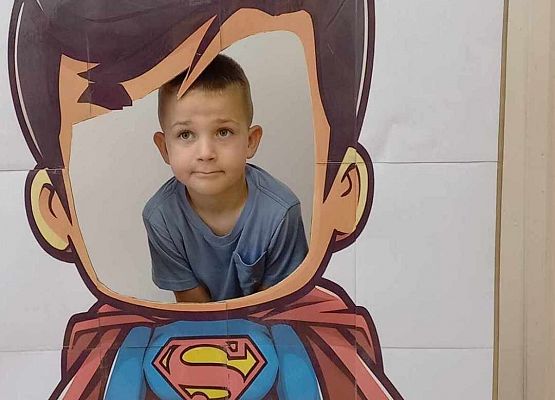 chłopiec pozuje do zdjęcia w fotobudce