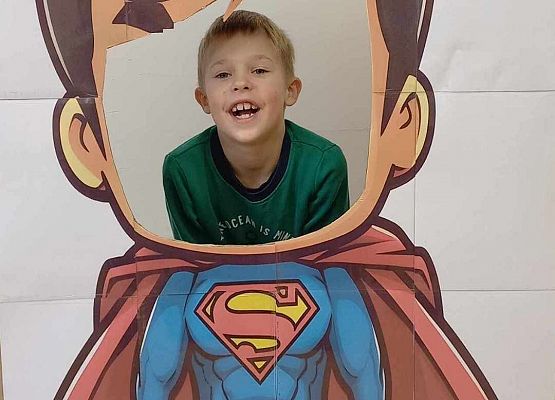 chłopiec pozuje do zdjęcia w fotobudce