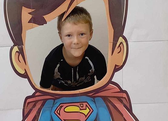 chłopiec pozuje do zdjęcia w fotobudce