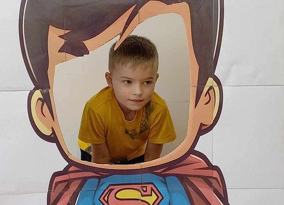 chłopiec pozuje do zdjęcia w fotobudce