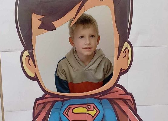 chłopiec pozuje do zdjęcia w fotobudce