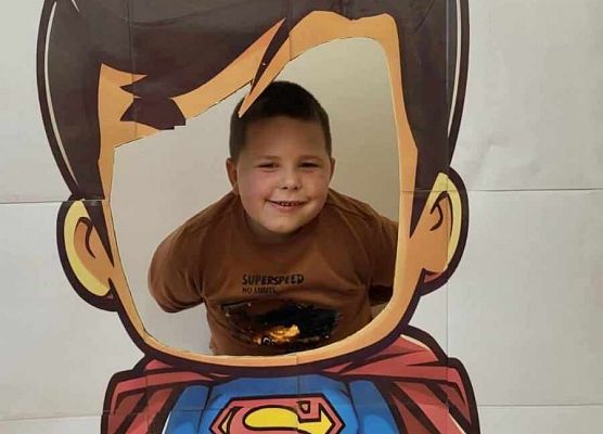 chłopiec pozuje do zdjęcia w fotobudce