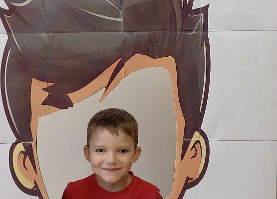 chłopiec pozuje do zdjęcia w fotobudce