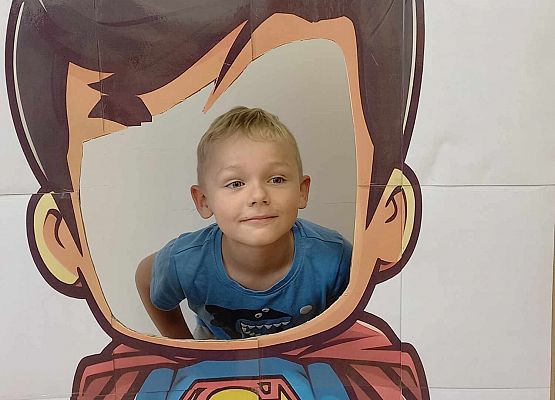 chłopiec pozuje do zdjęcia w fotobudce