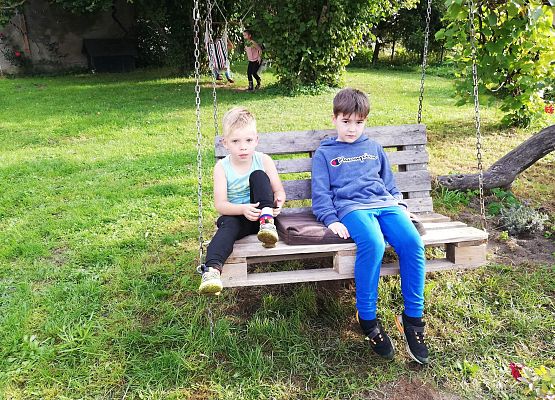 chłopcy siedzą na bujawce