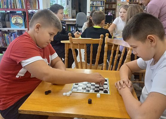 uczniowie grają w grę planszową