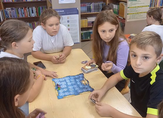 uczniowie grają w grę planszową