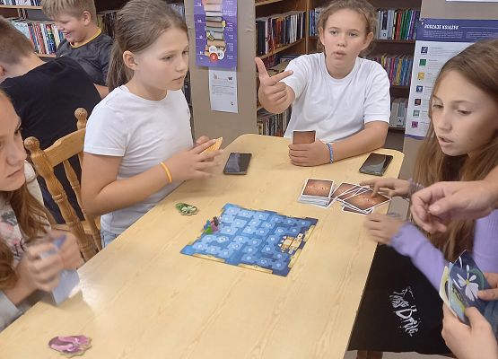 uczniowie grają w grę planszową