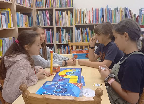 uczniowie grają w grę planszową