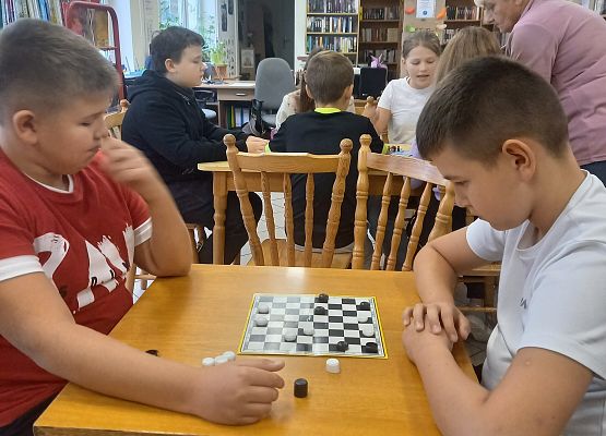 uczniowie grają w grę planszową