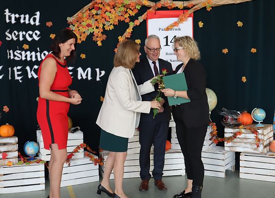 pani wicedyrektor wręcza kwiaty nagrodzonej nauczycielce, obok dyrektor i przewodnicząca Rady Rodziców