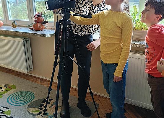 pani fotograf pokazuje uczniom sprzęt fotograficzny