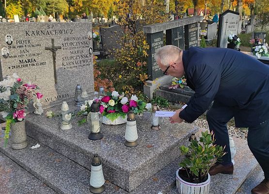 dyrektor kładzie znicz na grobie