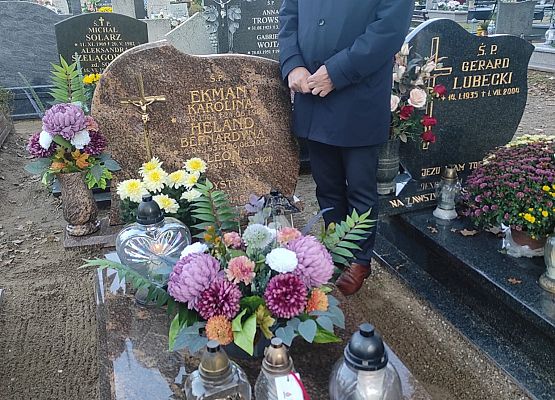 dyrektor kładzie znicz na grobie