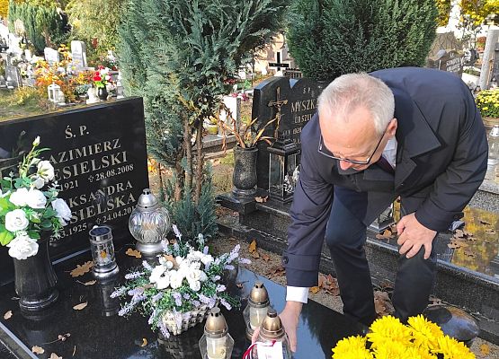 dyrektor kładzie znicz na grobie