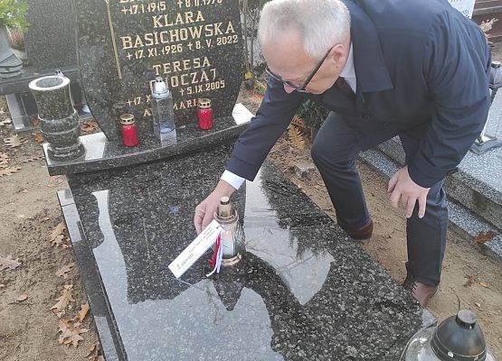 dyrektor kładzie znicz na grobie