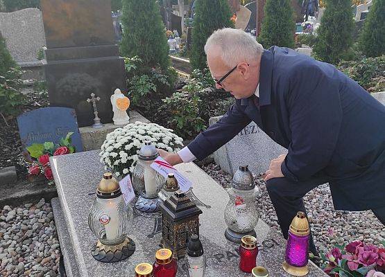 dyrektor kładzie znicz na grobie