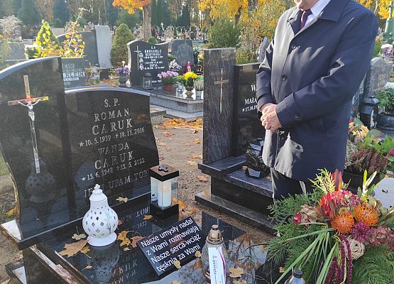 dyrektor stoi przy grobie