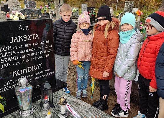 uczniowie stoją przy grobie