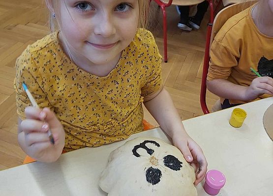 Dziewczynka maluje dynię