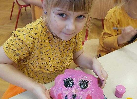 Dziewczynka pokazuje swoja pomalowaną dynię