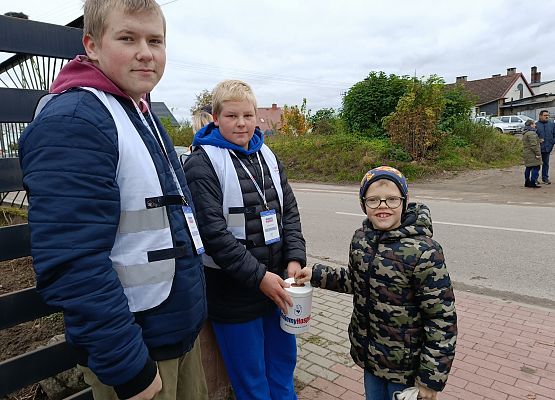 chłopiec wrzuca darowiznę do puszki