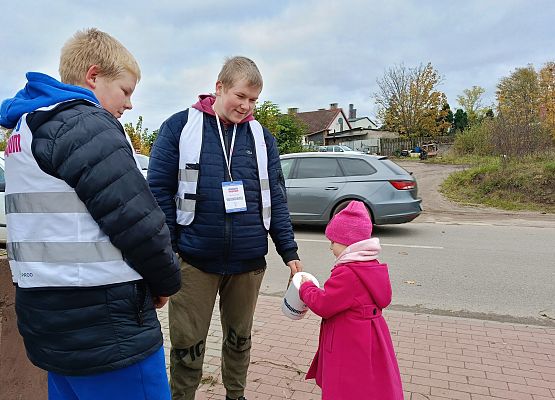 dziewczynka wrzuca darowiznę do puszki