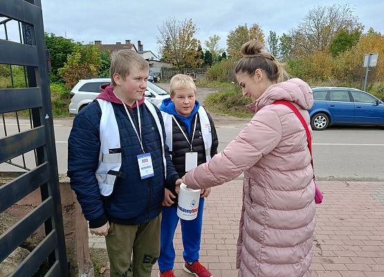 kobieta wrzuca darowiznę do puszki