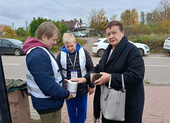 kobieta wrzuca darowiznę do puszki