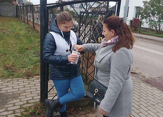 kobieta wrzuca darowiznę do puszki