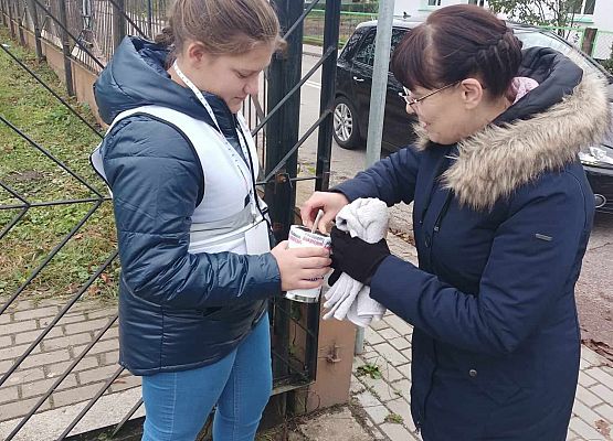 kobieta wrzuca darowiznę do puszki