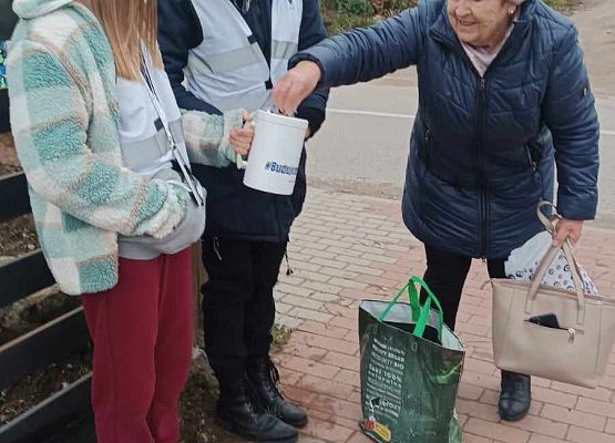 kobieta wrzuca darowiznę do puszki