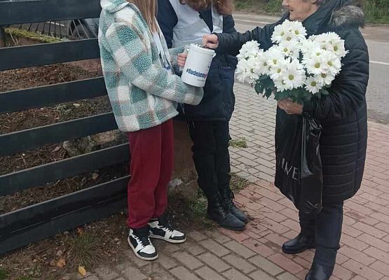 kobieta wrzuca darowiznę do puszki