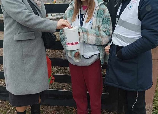 kobieta wrzuca darowiznę do puszki