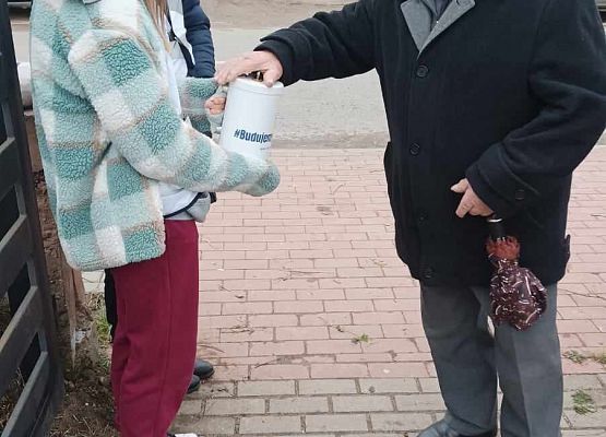 mężczyzna wrzuca darowiznę do puszki