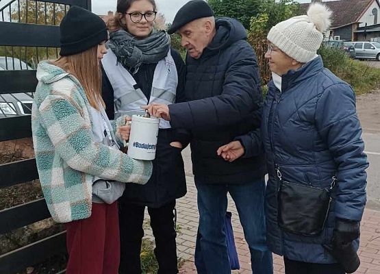 mężczyzna wrzuca darowiznę do puszki