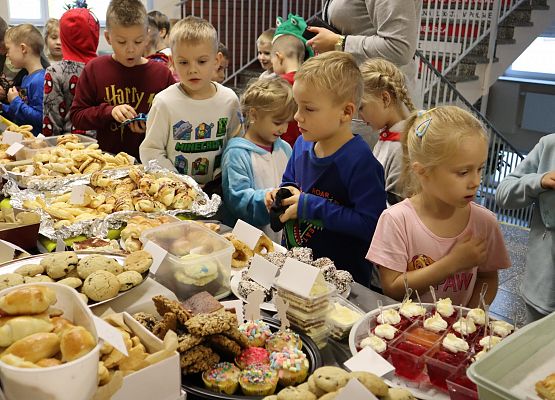 dzieci kupują wypieki na stoisku kiermaszowym