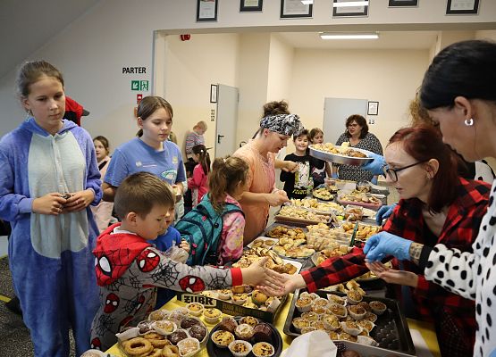 dzieci kupują wypieki na stoisku kiermaszowym