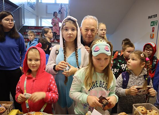 uczennice z dyrektorem przed stoiskiem