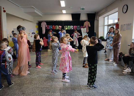 uczniowie i nauczycielka tańczą
