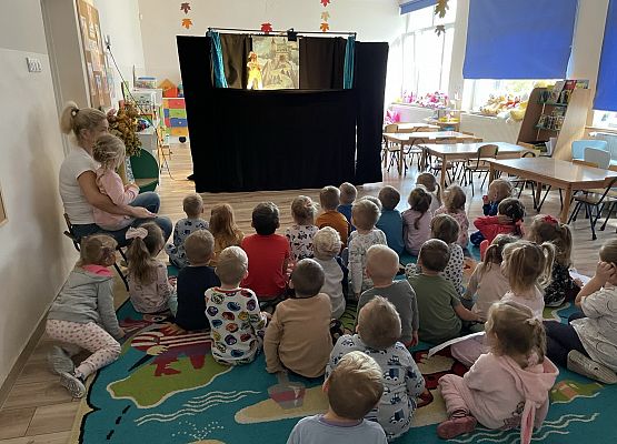 dzieci siedzą na dywanie