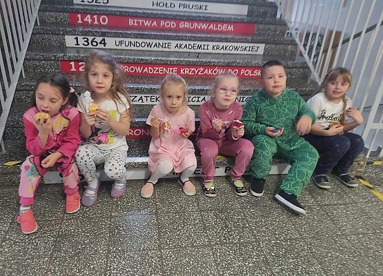 dzieci siedzą i jedzą ciastka