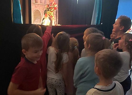 dzieci witają się z kukiełkami z teatrzyku