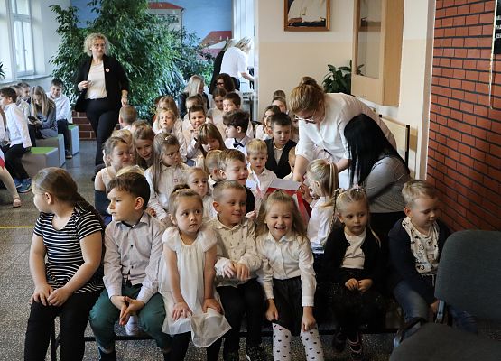 uczniowie siedzą w oczekiwaniu na akademię