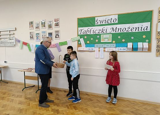 dyrektor częstuje dzieci słodyczami