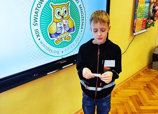 chłopiec stoi przy tablicy multimedialnej